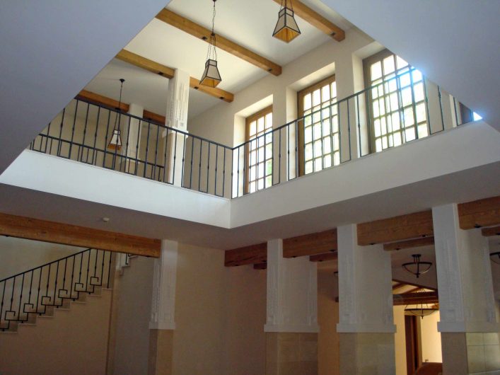 View of the hotel's internal porch with wooden patio doors on the upper floor