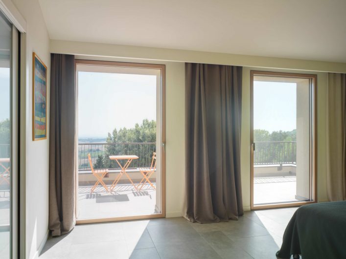View of the guest room of Villa Pisa with two closed single-leaf French windows