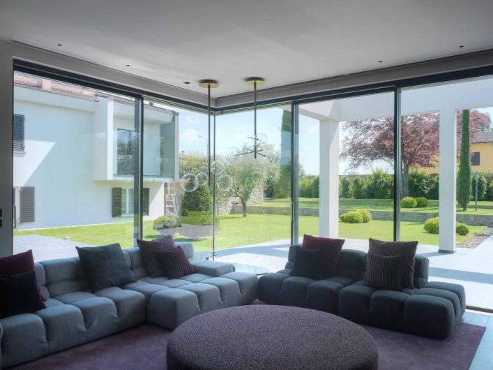 View of the living room of Villa Arezzo with Skyline lift and slide and all-glass corner